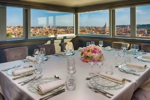 Sala panoramica della Casina Valadier con tavolo apparecchiato e vista su Roma