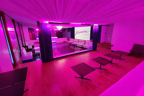 Sala dell’Heaven illuminata di rosa, con divani e tavolini bassi