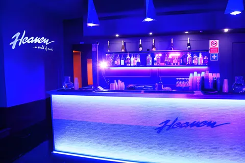 Bancone bar illuminato dell’Heaven con l’insegna del locale