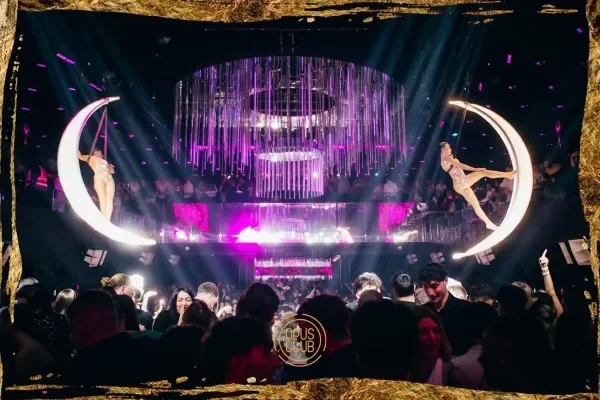 Sala dell’Opus Club di Roma illuminata di viola con installazioni luminose a forma di luna