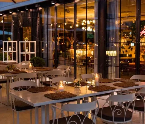 Sala ristorante di Profumo con tavoli apparecchiati e vetrate