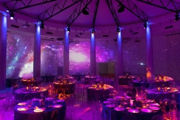 Sala del Salone delle Colonne allestita per il cenone di Capodanno con tavoli rotondi e luci scenografiche
