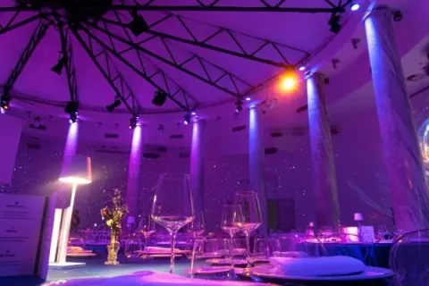 Sala del Salone delle Colonne illuminata di viola con tavoli e colonne
