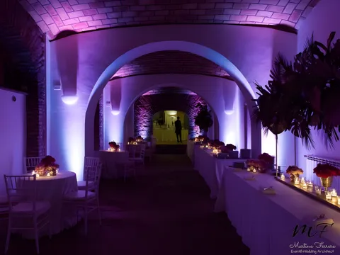 Galleria a volte di Villa dei Cesari illuminata di viola, con tavolo imperiale