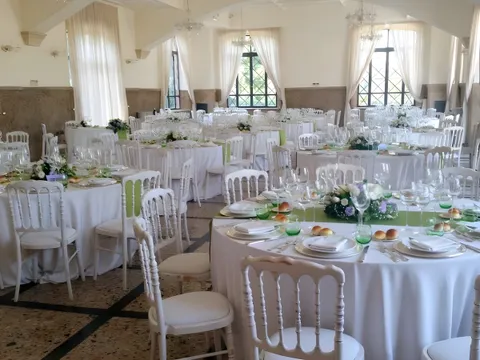 Salone di Villa dei Cesari con tavoli rotondi apparecchiati di bianco