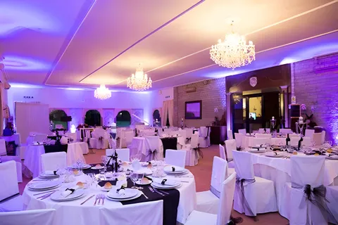 Sala di Villa dei Principi con luci viola e tavoli apparecchiati di bianco